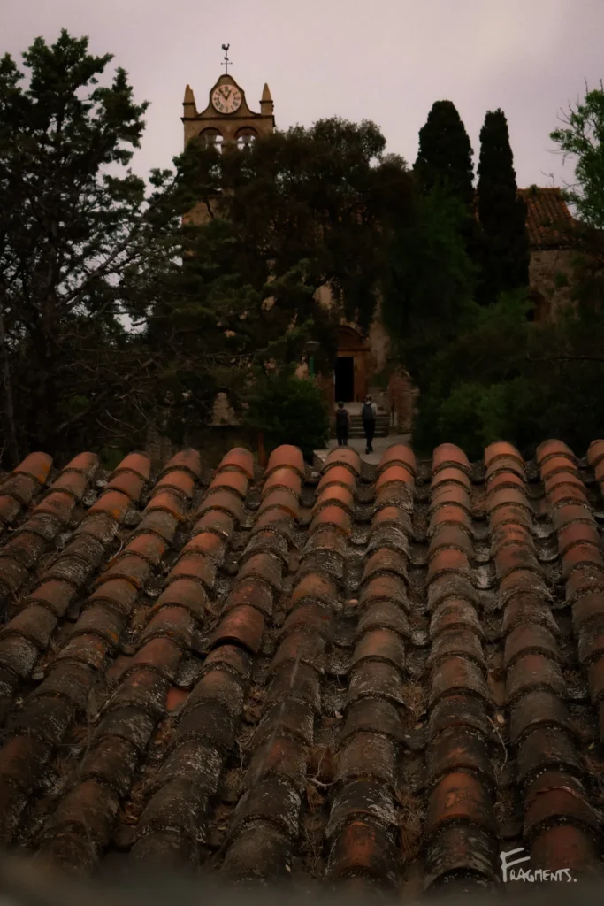 Voyage poétique et photographique à travers Castelnou : Photo de loin d'un couple marchant vers l'entrée de l'église Sainte-Marie-de-Marcadal dans les Pyrénées-Orientales