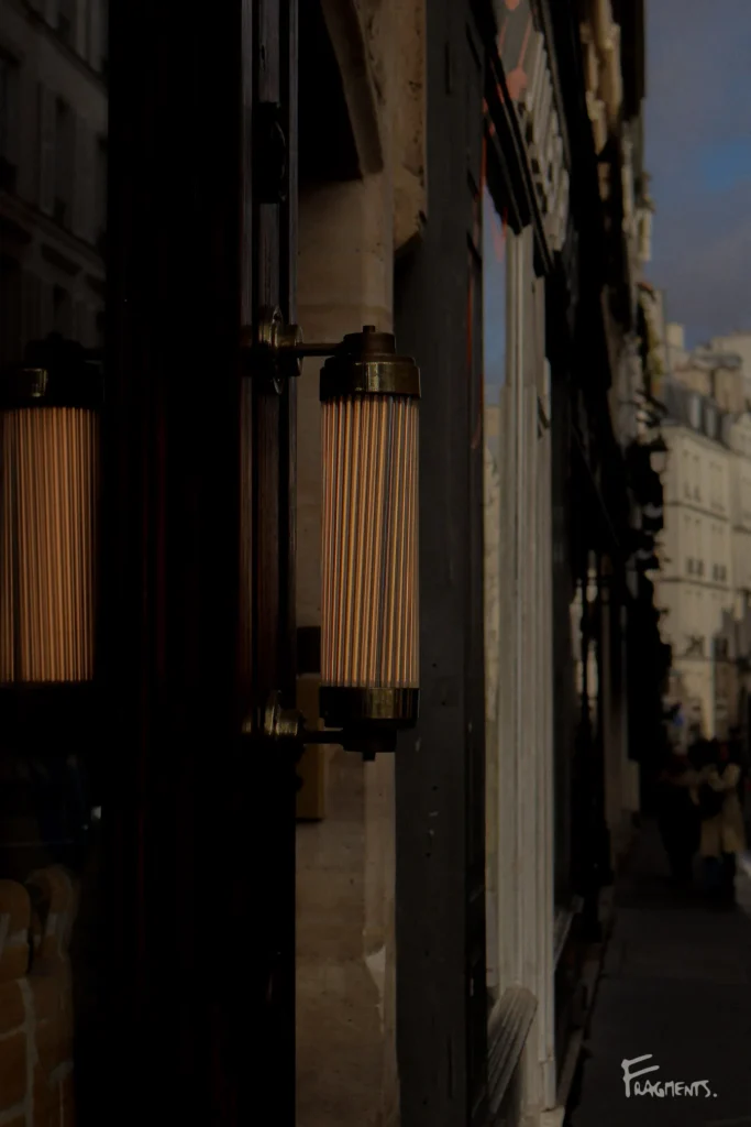 Voyage poétique et photographique à travers Paris : Lampe design ancienne sur la façade d'un restaurant parisien