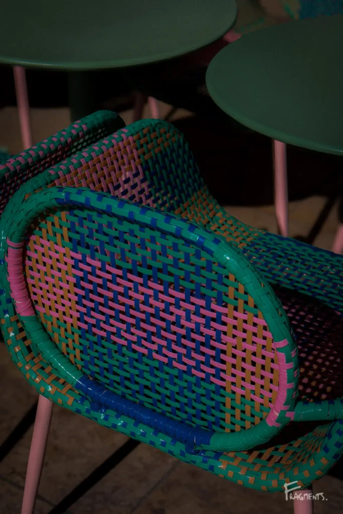 Focus sur chaise vide avec détails bleu, vert et rose dans une ruelle de Montpellier
