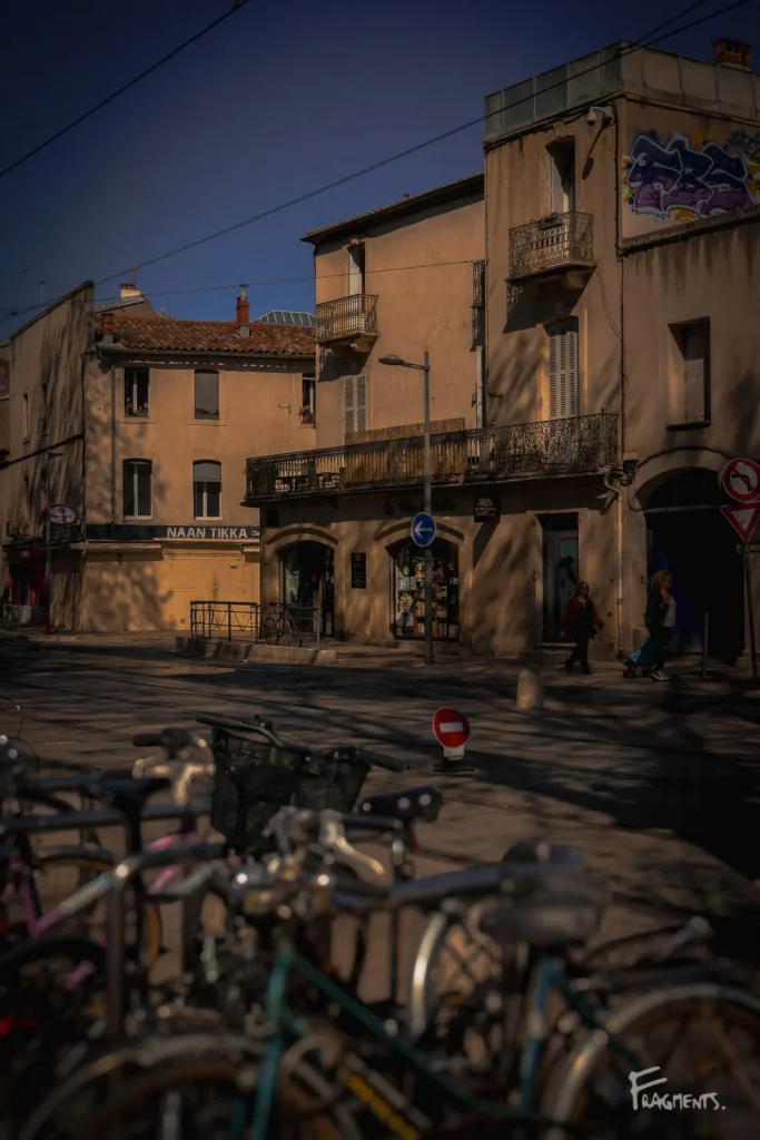 Vélos au premier plan, dans une rue de Montpellier, un jour de printemps