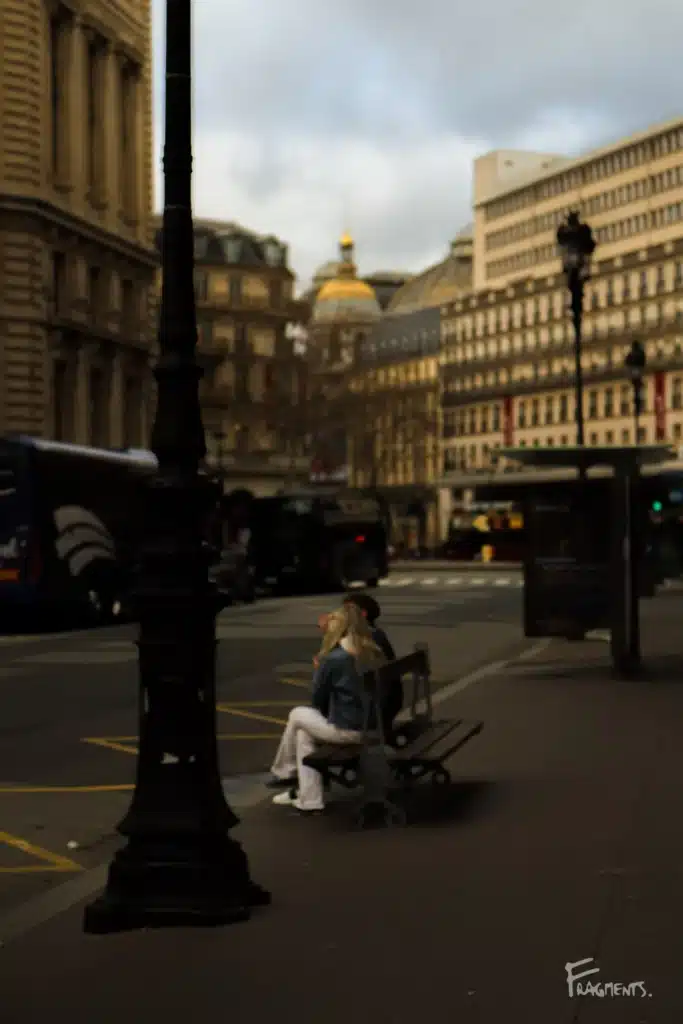 Voyage poétique et photographique à travers Paris : Jeune couple assis sur un banc dans le quartier d'Opéra